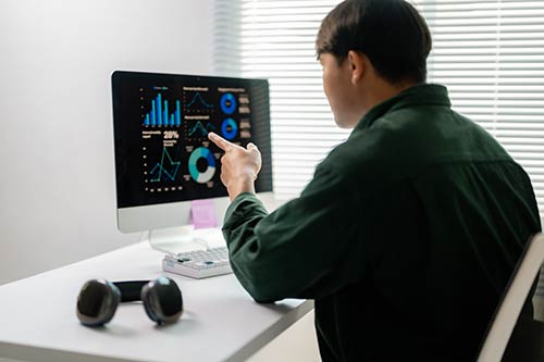IT specialist monitors domain controller performance with real-time graphs on screen.